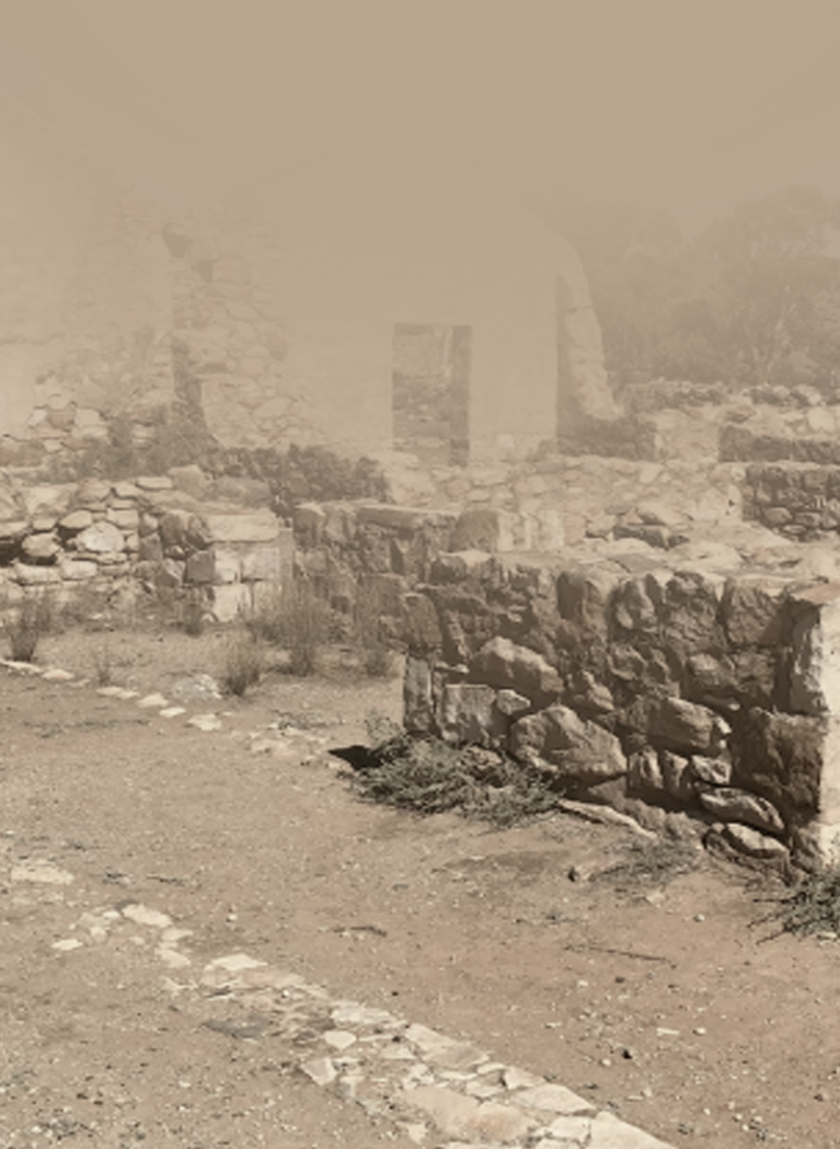 Desert village with low brick wall and dusty street 