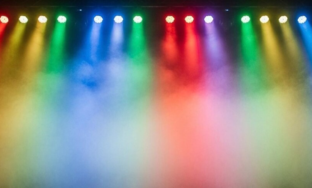 Stage with rainbow coloured spotlights and dry ice mist