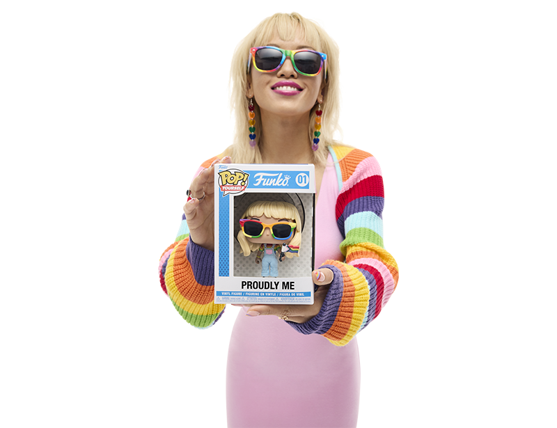 Model wearing rainbow accessories and apparel holding a Funko Pop! Yourself with pride accessories