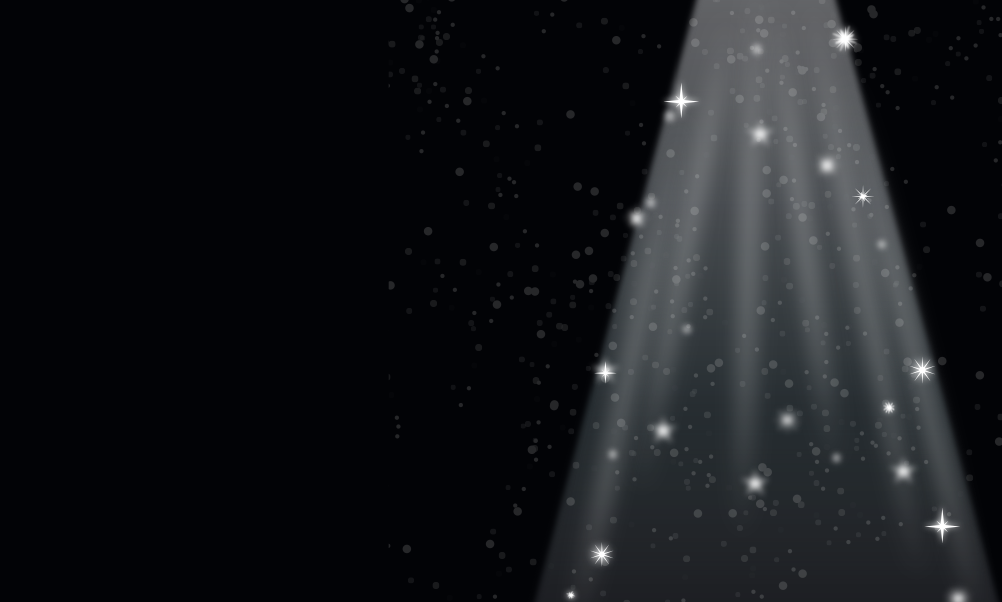 Black stage background with a bright white spotlight shining through sparkling stars and floating light particles, creating a magical, glamorous atmosphere.